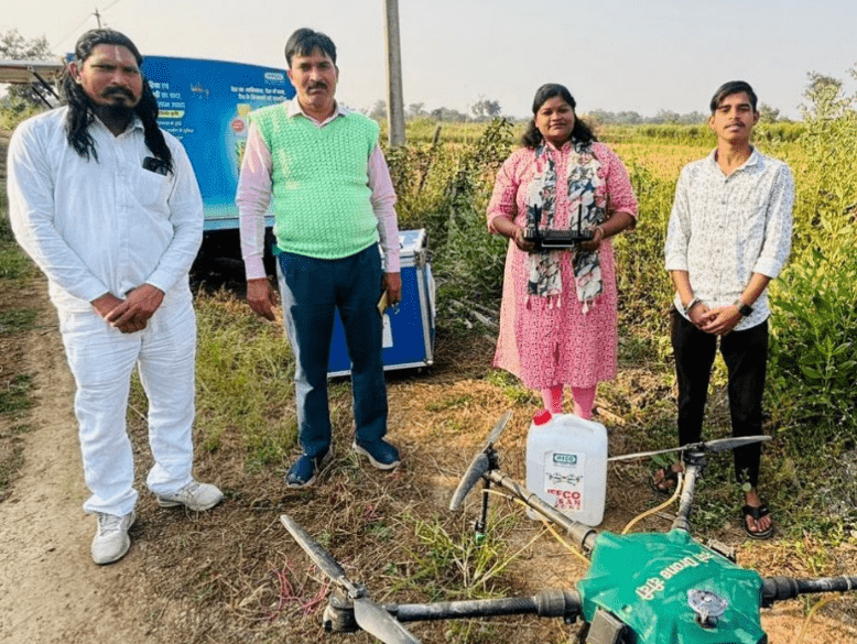 ड्रोन दीदी योजना के तहत किसानों के खेत में छिड़काव करते हुए महिला